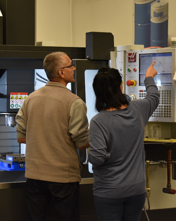 instructor with student at computer manufacturing equipment