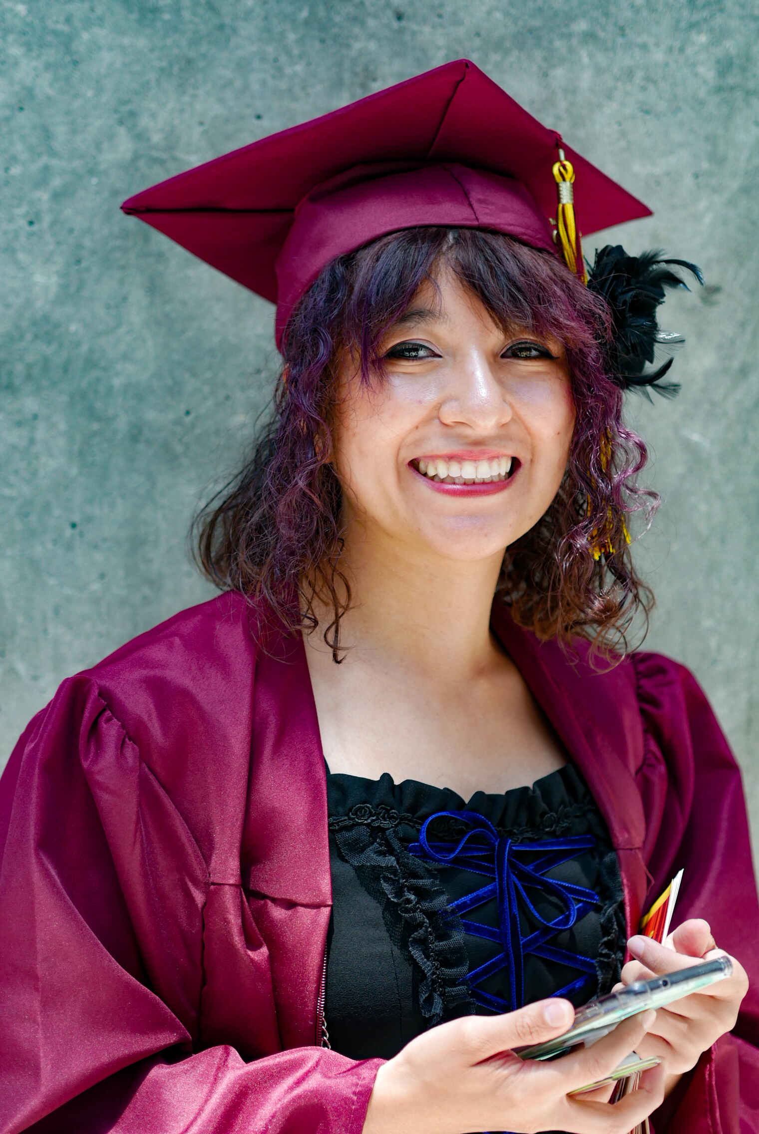 smiling young woman in grad regalia 
