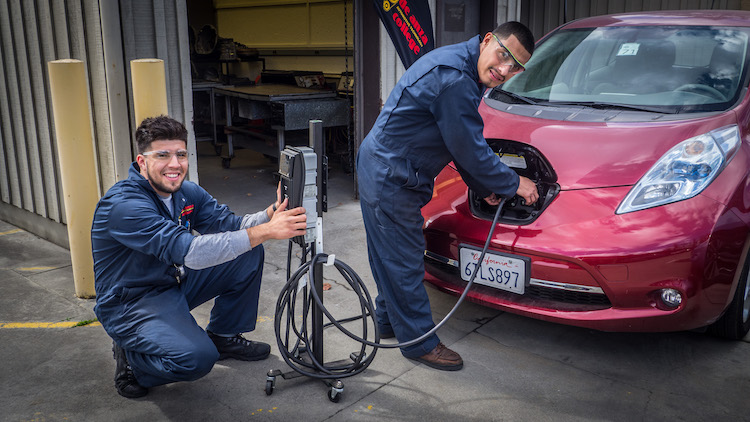 two young men working on car