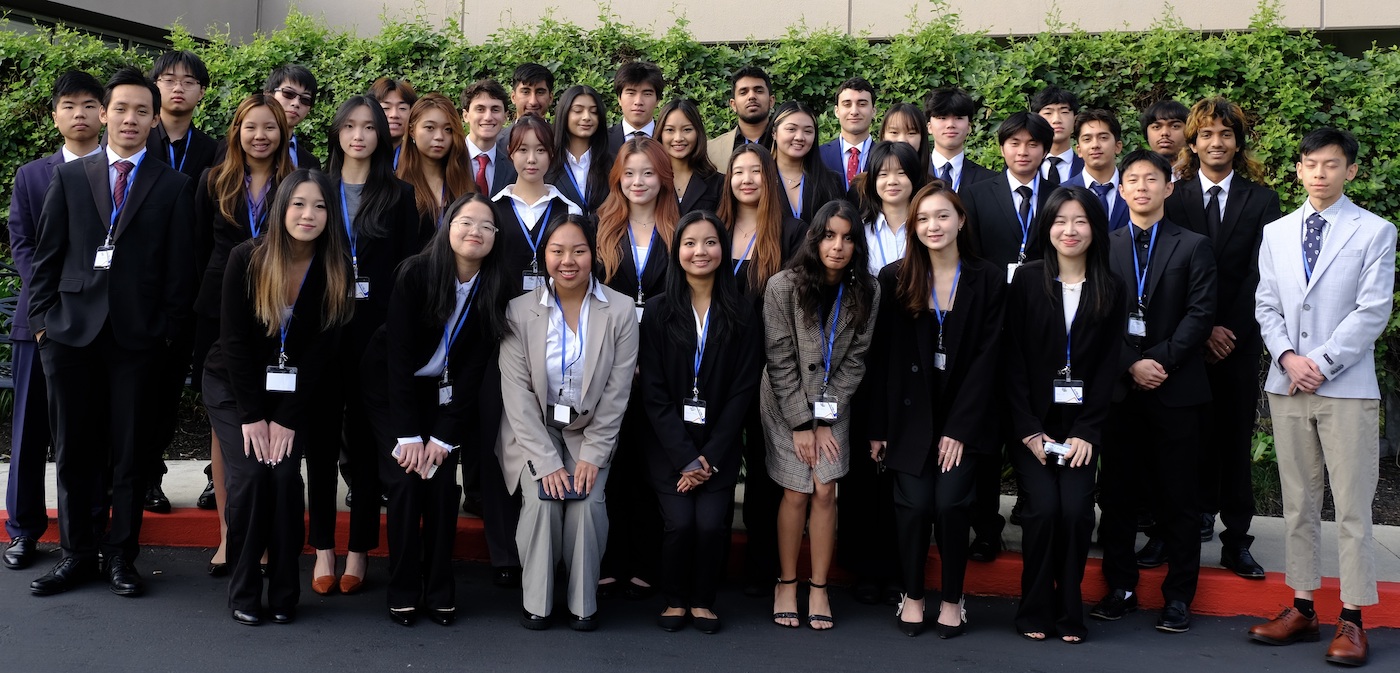 large group of students posing in business suits