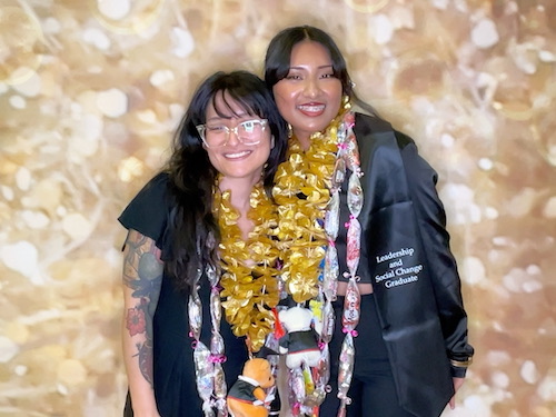 two students with gold leis
