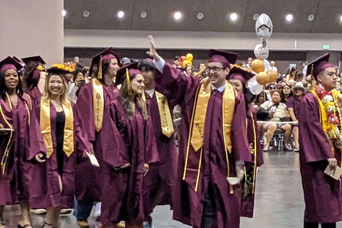 student waving from line of grads